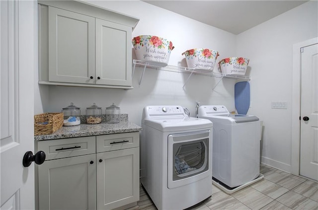 laundry room featuring baseboards, cabinet space, and independent washer and dryer