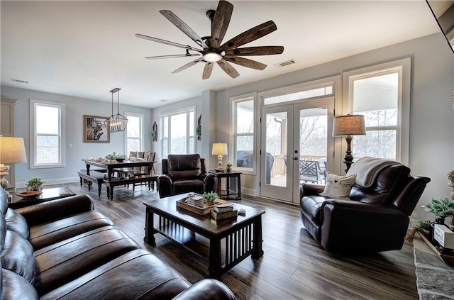 living area featuring visible vents, wood finished floors, french doors, baseboards, and ceiling fan