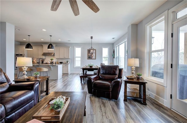 living room featuring recessed lighting, wood finished floors, baseboards, and ceiling fan