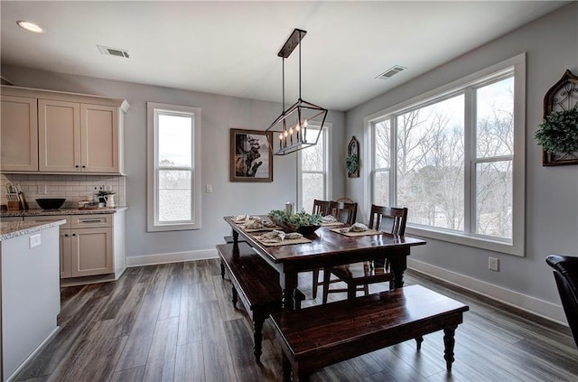 dining space with dark wood finished floors, baseboards, and visible vents