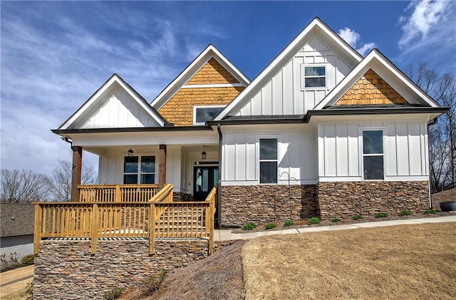 craftsman-style home featuring stone siding, covered porch, and board and batten siding