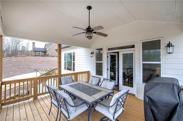 wooden deck featuring outdoor dining area, a grill, a ceiling fan, and fence