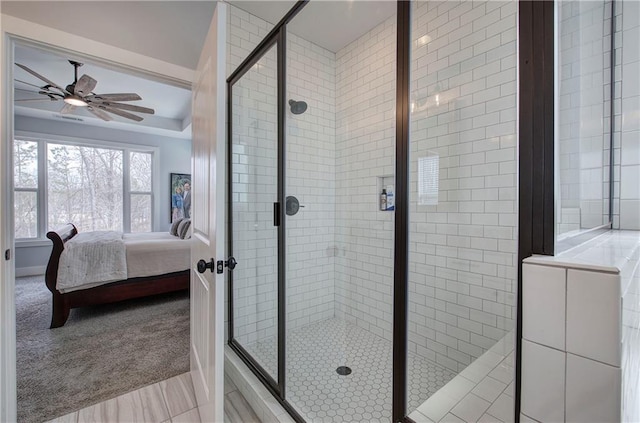 ensuite bathroom with a stall shower, ceiling fan, and ensuite bathroom