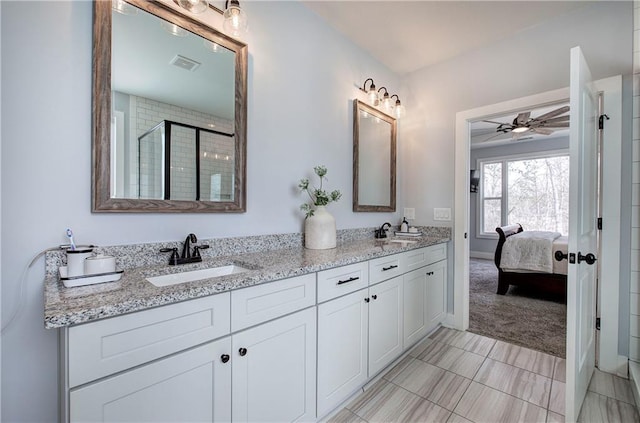 full bath featuring a sink, visible vents, double vanity, and a shower stall