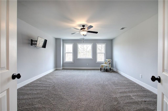 spare room featuring visible vents, carpet floors, baseboards, and a ceiling fan