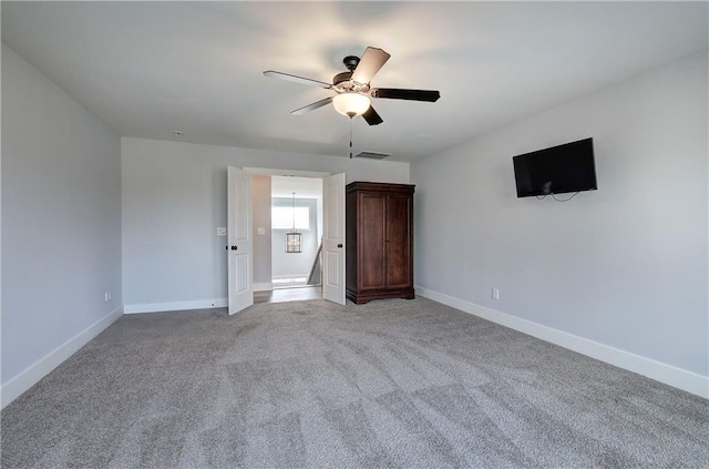 unfurnished bedroom featuring visible vents, light colored carpet, a ceiling fan, and baseboards