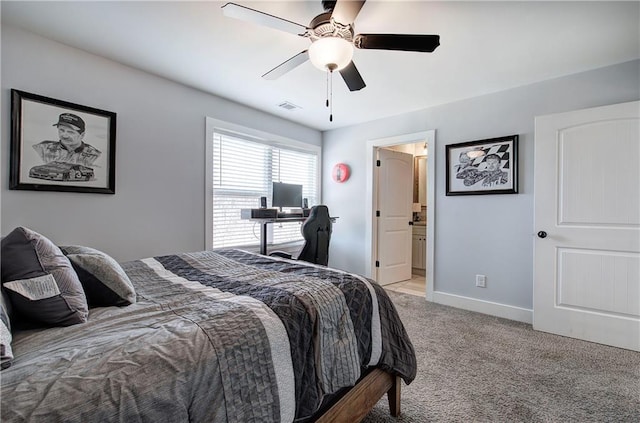 bedroom featuring visible vents, light carpet, ensuite bathroom, baseboards, and ceiling fan