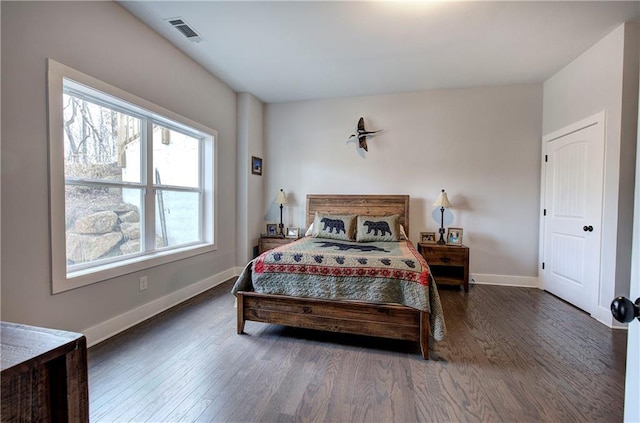 bedroom with visible vents, baseboards, and wood finished floors