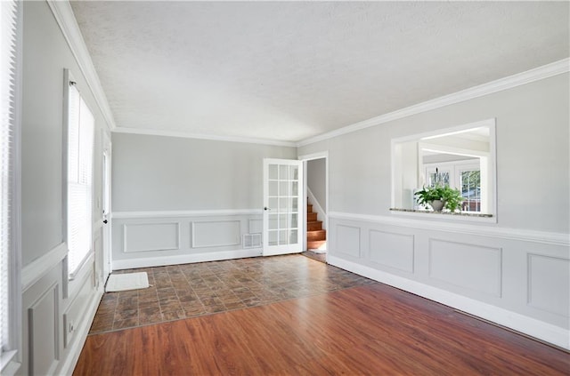 unfurnished room featuring dark hardwood / wood-style flooring, ornamental molding, and a healthy amount of sunlight