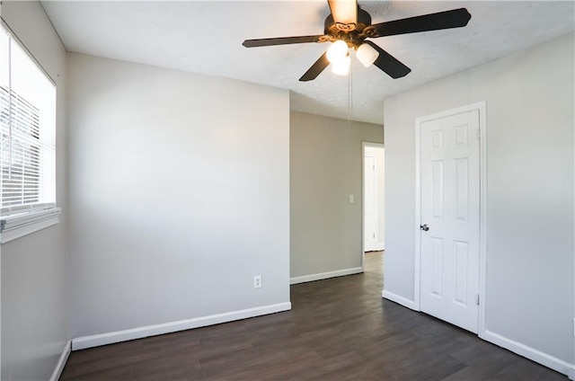 spare room featuring ceiling fan and dark wood-type flooring