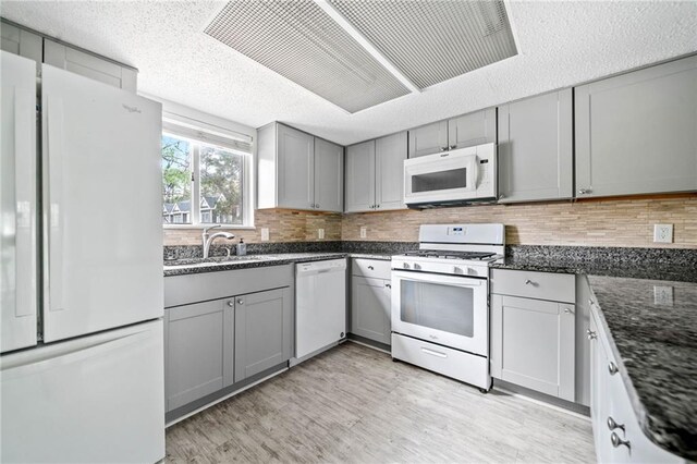 66 Fair Haven Way SE, Smyrna, GA 30080 - kitchen with white appliances, gray cabinets, dark stone counters, and light wood-type flooring