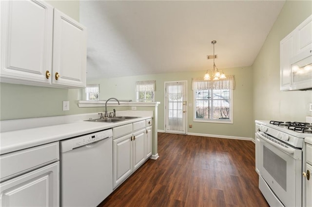 kitchen featuring pendant lighting, lofted ceiling, sink, white cabinets, and white appliances