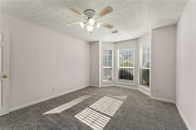 carpeted spare room featuring ceiling fan and a textured ceiling