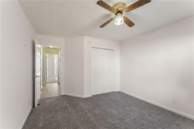 unfurnished bedroom featuring ceiling fan, dark carpet, and a closet