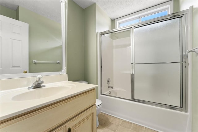 full bathroom featuring bath / shower combo with glass door, vanity, a textured ceiling, and toilet