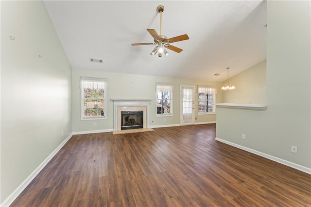 unfurnished living room with lofted ceiling, dark hardwood / wood-style floors, and ceiling fan with notable chandelier