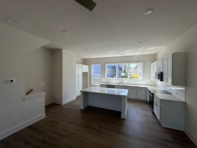 1392 Cozy Cir Unit 349, Atlanta, GA 30315 - kitchen featuring stainless steel microwave, light countertops, and dark wood finished floors