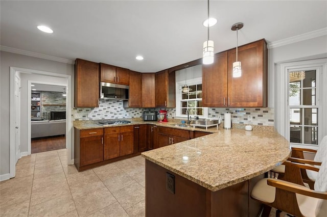 3912 Edenton Ct NE, Brookhaven, GA 30319 - kitchen with appliances with stainless steel finishes, a peninsula, backsplash, crown molding, and decorative light fixtures