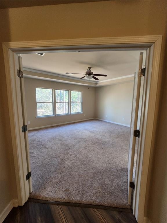 spare room with ceiling fan and dark carpet