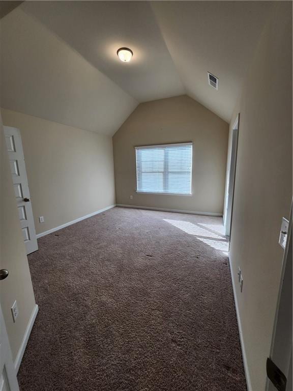 bonus room featuring dark carpet and vaulted ceiling