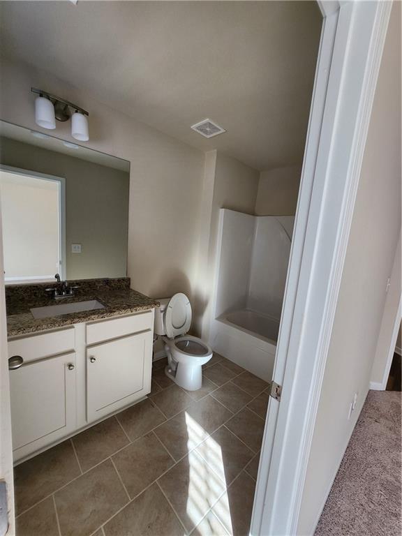 full bathroom featuring vanity, tile patterned floors, toilet, and shower / washtub combination