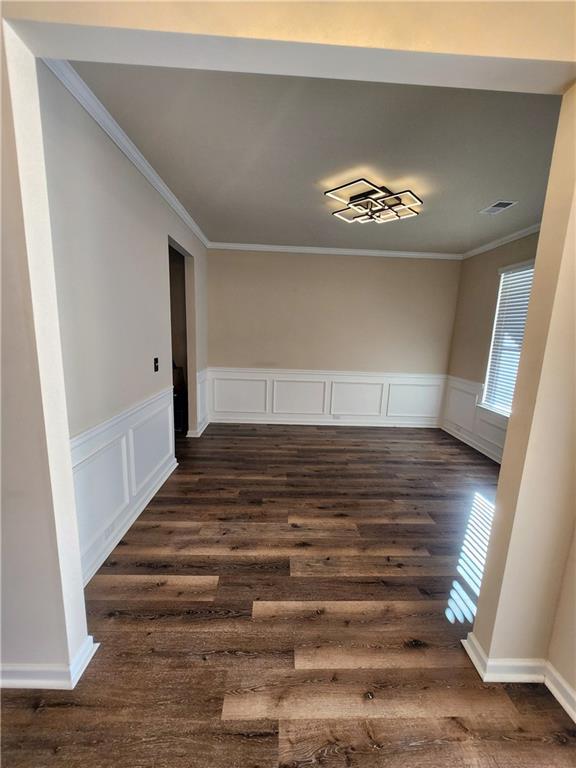 unfurnished dining area with crown molding and dark hardwood / wood-style flooring