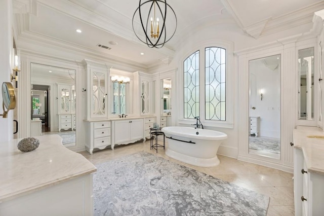 bathroom with tile patterned flooring, vanity, ornamental molding, a bathing tub, and an inviting chandelier