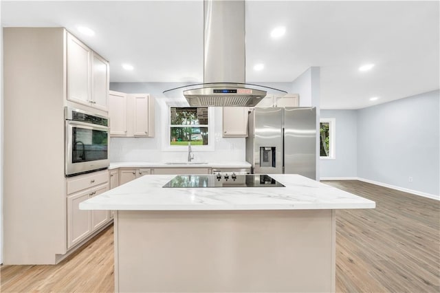 3355 Wesley Chapel Rd, Decatur, GA 30034 - kitchen featuring appliances with stainless steel finishes, island exhaust hood, a sink, backsplash, and light wood-style floors