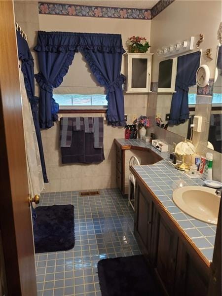 bathroom with vanity and tile walls