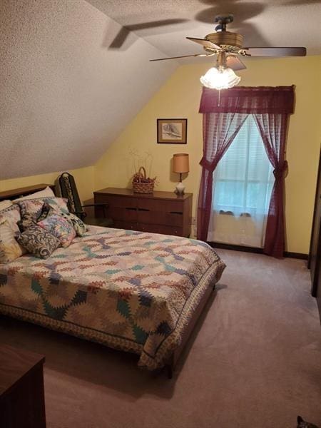 bedroom featuring lofted ceiling, ceiling fan, a textured ceiling, and carpet