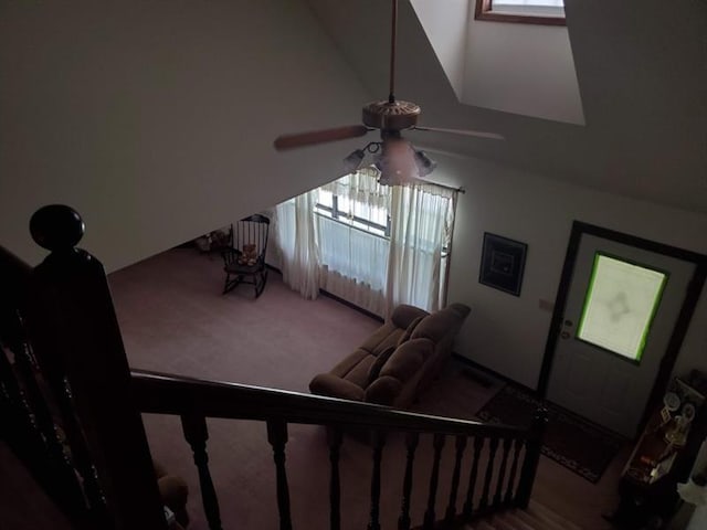 living room with lofted ceiling, ceiling fan, and carpet flooring