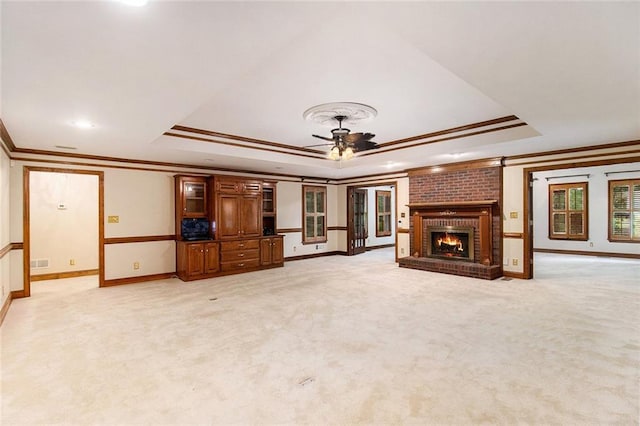 402 Clyde Ct, Mcdonough, GA 30252 - unfurnished living room featuring a raised ceiling, ornamental molding, a ceiling fan, light carpet, and a fireplace