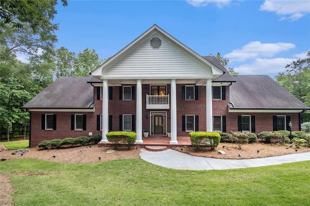 402 Clyde Ct, Mcdonough, GA 30252 - neoclassical / greek revival house featuring a balcony, a front yard, and brick siding