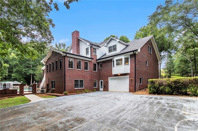 402 Clyde Ct, Mcdonough, GA 30252 - view of home's exterior with a chimney, brick siding, driveway, and an attached garage