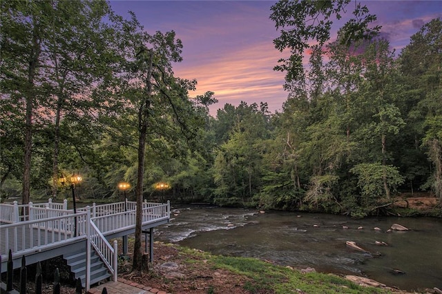 402 Clyde Ct, Mcdonough, GA 30252 - yard at dusk featuring a deck, a wooded view, and stairs