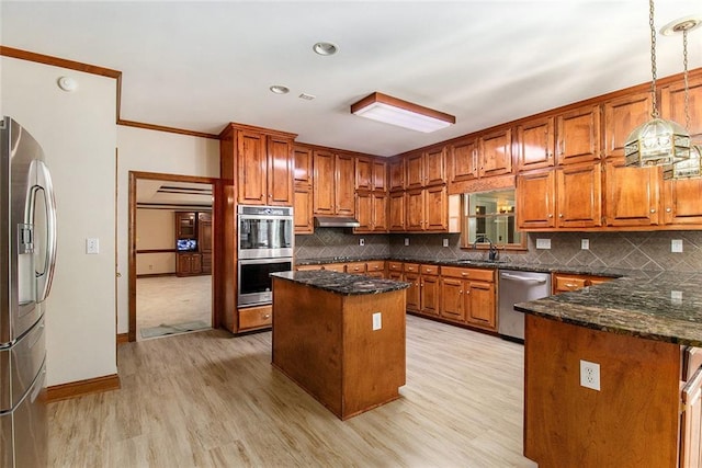402 Clyde Ct, Mcdonough, GA 30252 - kitchen featuring stainless steel appliances, a kitchen island, brown cabinetry, light wood-style flooring, and tasteful backsplash