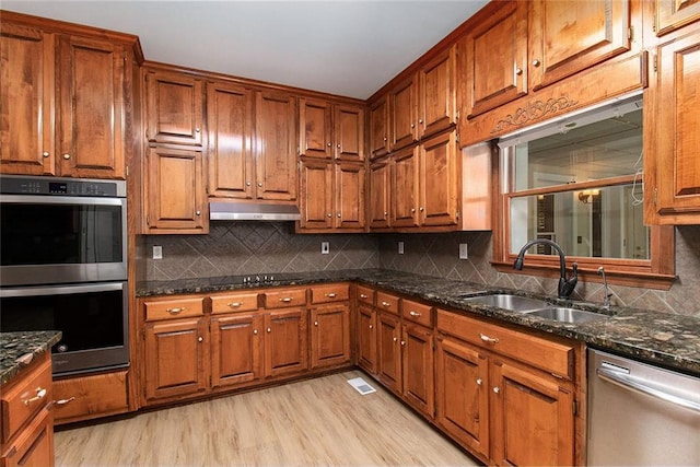 402 Clyde Ct, Mcdonough, GA 30252 - kitchen with appliances with stainless steel finishes, brown cabinets, backsplash, and under cabinet range hood