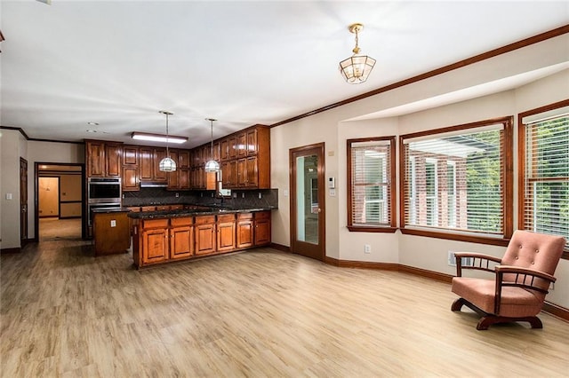 402 Clyde Ct, Mcdonough, GA 30252 - kitchen featuring light wood-style floors, decorative backsplash, pendant lighting, under cabinet range hood, and crown molding