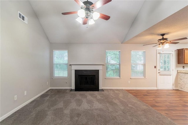 6304 Kendra Ln, Lithonia, GA 30058 - unfurnished living room with lofted ceiling, a ceiling fan, a fireplace with flush hearth, carpet floors, and wood finished floors