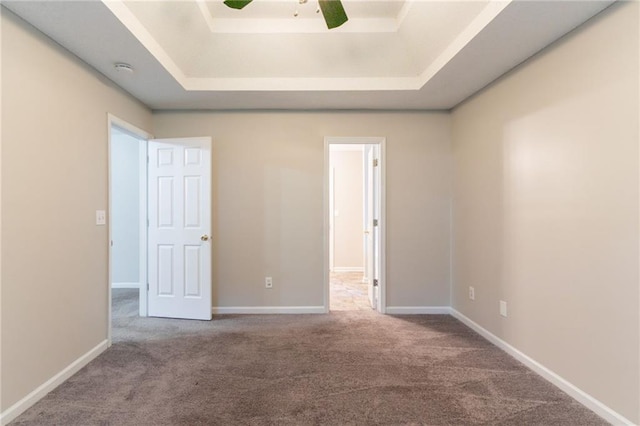 6304 Kendra Ln, Lithonia, GA 30058 - unfurnished bedroom with carpet floors, a tray ceiling, and a ceiling fan