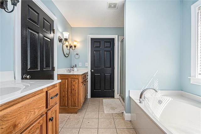 bathroom with tile patterned flooring, two vanities, a stall shower, and visible vents