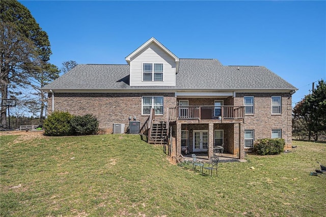 rear view of property with a lawn, brick siding, french doors, and a deck