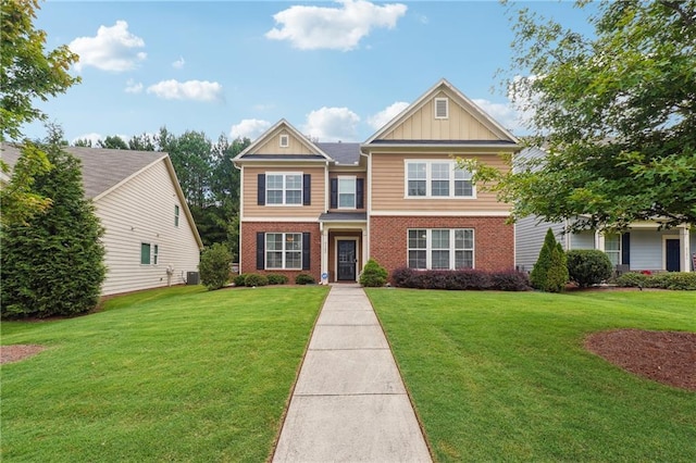 traditional-style home featuring board and batten siding, cooling unit, brick siding, and a front lawn