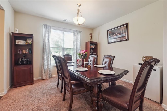 dining room featuring light carpet, visible vents, and baseboards