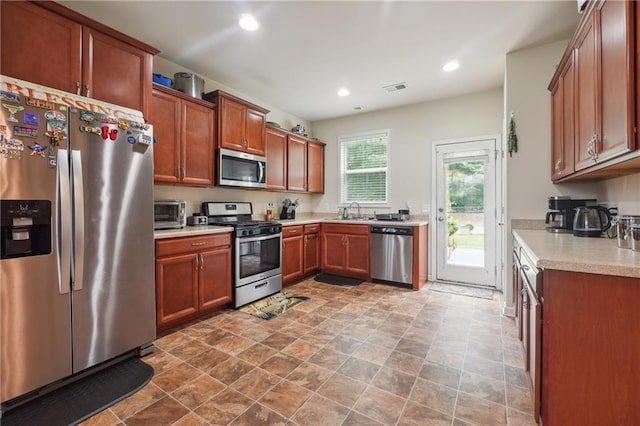 kitchen with recessed lighting, light countertops, visible vents, appliances with stainless steel finishes, and a sink