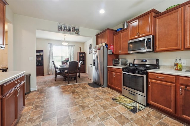 kitchen with stainless steel appliances, brown cabinetry, light countertops, and a toaster