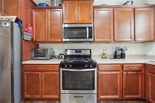 kitchen featuring stainless steel appliances, light countertops, and a toaster