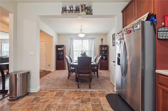 carpeted dining space featuring baseboards