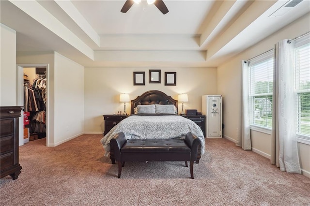 bedroom with carpet floors, a tray ceiling, visible vents, a spacious closet, and baseboards