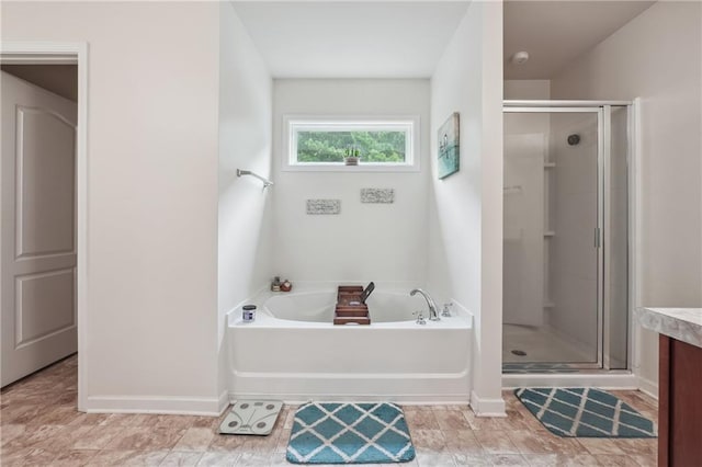 bathroom featuring a shower stall, baseboards, a bath, and vanity